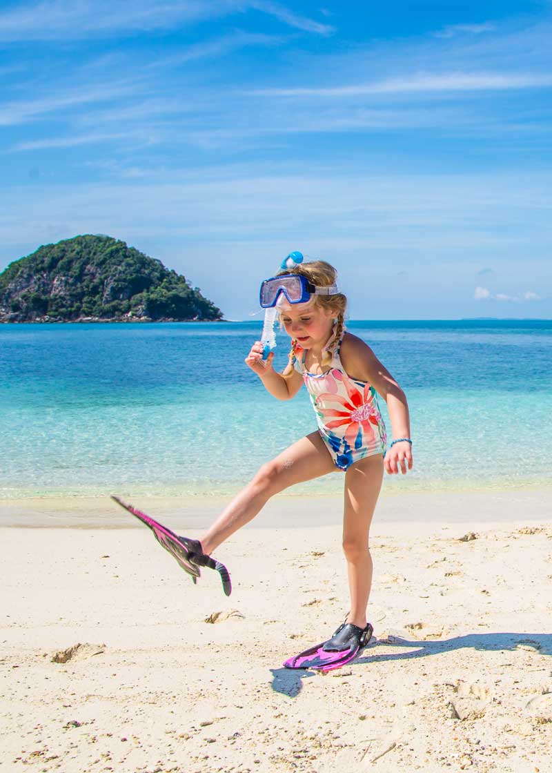 little girl walking in flippers and mask and snorkel 
